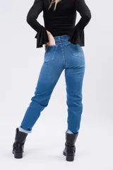 Jean mom de tiro alto con corte recto, confeccionado en denim azul clásico. Presenta cierre frontal con botón y bolsillos laterales y traseros.