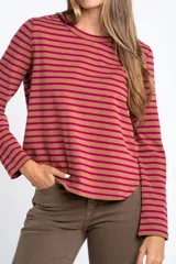 Remera de manga larga con diseño de rayas horizontales en blanco y negro, cuello redondo y corte ajustado al cuerpo.