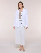 Sobrecamisa beige de lino liviano, con cuello camisero, cierre frontal de botones carey y bolsillos en el pecho. Cuenta con cordón ajustable en la cintura y mangas largas.
