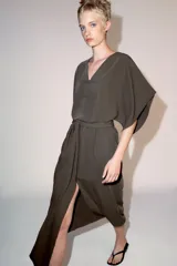 Vestido midi ZW Collection de color verde militar, con escote en pico, mangas anchas por debajo del codo y cierre frontal con alamares. Cuenta con un cinturón del mismo tejido para anudar en la cintura y bajo acabado en línea evasé.
