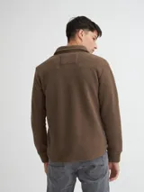 Camisaco color beige confeccionado en sherpa (corderito) con cartera de botones de pasta a tono y bolsillos con solapa en pecho.