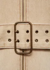 Vestido corto de algodón estilo denim, con diseño entallado, cuello halter y cierre frontal con cremallera. Incluye un cinturón decorativo integrado con hebilla metálica y costuras a la vista.