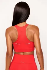 Top deportivo de alto rendimiento con diseño de espalda nadador, confeccionado en tejido técnico con protección UV50+. Presenta un bolsillo interno en el forro frontal y detalles reflectivos.