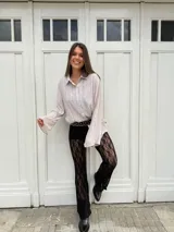 Pantalón de encaje negro con corte acampanado y cintura alta.