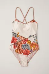 Malla enteriza de color beige con estampado de corales y elementos marinos en tonos rojos, naranjas y azules, con tirantes finos cruzados en la espalda.
