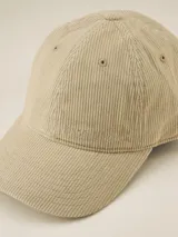 Gorra de béisbol color ocre, confeccionada en pana con visera curva y botón superior.