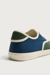 Zapatilla casual de hombre con diseño combinado en color naranja y marrón oscuro, con cordones y suela de goma en contraste.