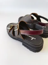 Sandalias de cuero color chocolate con plataforma track negra y hebillas metálicas plateadas.