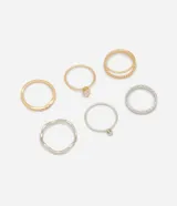 Set de seis anillos de diseño variado en tonos dorados y plateados, que incluye modelos lisos, con texturas trenzadas y anillos finos con incrustaciones de piedras brillantes.