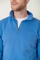 Sweater azul de algodón con cuello alto y medio cierre con cremallera.