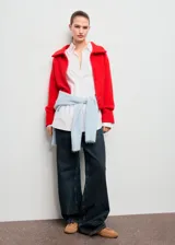 Cardigan de punto grueso color rojo, con diseño recto, cuello camisero, cierre frontal de cremallera doble y mangas largas con puños acanalados.