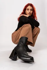 Bota de caña media color negro, de cuero, con horma cuadrada, taco geométrico con textura símil cocodrilo y plataforma.