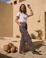Pantalón de lino rayado, de corte ancho y relajado, con cintura elástica con cordón de ajuste y prácticos bolsillos laterales.