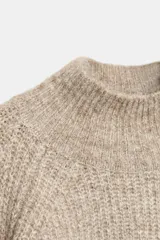 Jersey de punto con cuello subido y mangas largas abullonadas con puños ajustados.