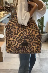 Bolso tote de cuero con estampado animal print en tonos beige y marrón.