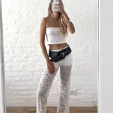 Pantalón ancho de encaje blanco con diseño floral, tiro alto y elástico en la cintura.