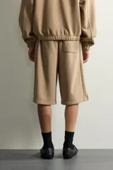 Bermuda estilo jogger de ajuste relajado, color beige, con cintura elástica ajustable mediante cordón y bolsillos delanteros.
