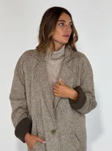 Tapado largo color beige con diseño de espiga, confeccionado en paño de lana y forrado en su interior.