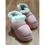 Pantuflas botitas color tostado con diseño acolchado y plataforma, forradas con corderito sintético blanco en el interior y el cuello. Cuentan con una pequeña etiqueta decorativa en el lateral.