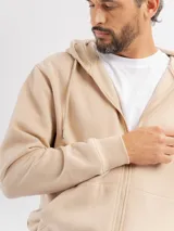 Campera de felpa color beige con capucha, cierre frontal completo y puños acanalados.