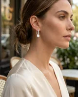 Aros colgantes de plata 925, con diseño de argolla pequeña decorada con circonias y una perla blanca en el extremo.