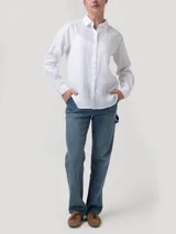 Blusa de lino orgánico color blanco, con cuello camisero, cierre frontal con botones y mangas largas.