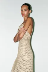 Vestido largo color dorado, confeccionado en tejido tipo red con aplicación de strass, escote pico y tirantes finos. Incluye forro interior y cierre en espalda con cremallera oculta en costura.