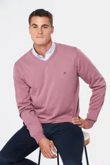 Suéter de tejido fino color azul marino, con cuello en V y manga larga. Presenta un pequeño logo bordado en el pecho.