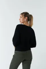 Sweater negro de punto liviano con textura acanalada y diseño de hombros caídos.