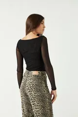 Top de manga larga confeccionado en tejido de tul con transparencias, de corte ajustado y cuello redondo.