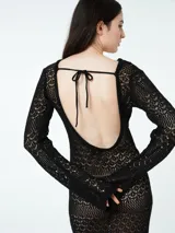 Vestido largo de crochet negro con mangas largas acampanadas y cinturón.