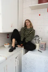 Blusa de algodón con estampado a cuadros en tonos azul y negro, con bordados decorativos en color bordó sobre el canesú. Presenta cierre frontal con botones, cuello redondo y mangas largas levemente abullonadas.