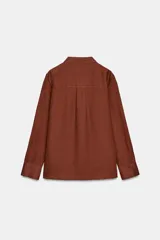 Camisa de lino 100% color beige claro, de manga larga y cuello solapa, con cierre frontal de botones.