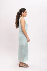 Vestido midi tejido de punto color celeste con detalles de tramas caladas en la parte frontal y en el sector inferior de la falda, cuello redondo y diseño sin mangas.
