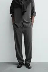 Pantalón de corte relaxed fit, con cintura ajustable, bolsillos delanteros y bolsillo trasero de plastrón. Presenta cierre frontal con cremallera y botón.