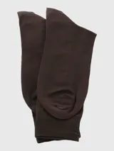 Calcetín de vestir largo, color marrón oscuro, con tejido fino y elástico acanalado en la caña. Presenta el logo de Hush Puppies grabado sutilmente en la parte inferior de la caña.