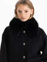 Chaqueta de paño color negro con cuello desmontable de piel sintética, bolsillos plaqué frontales y cierre con botones metálicos.