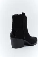Bota corta estilo western de gamuza color marrón, con taco cuadrado negro y puntera estilizada. Presenta un detalle de estrella aplicada en el lateral y tirador en la parte superior.