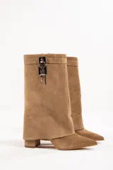 Bota de cuero color beige con punta fina, taco de 10cm y detalle de candado plateado en la caña.