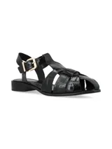 Sandalias planas de cuero color negro con efecto texturizado tipo reptil, diseño de tiras cruzadas y cierre de hebilla metálica dorada en el tobillo.