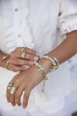 Brazalete rígido abierto de metal color plateado con textura irregular.