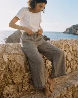 Pantalón capri de lino color gris, con cintura elástica ajustable con cordón y detalles de flecos en los dobladillos.