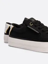 Zapatillas Tommy Hilfiger Essential de plataforma, color negro, confeccionadas en lona de algodón. Presentan suela de goma blanca, interior de poliéster, plantilla extraíble y logo metálico en la lengüeta y el lateral.
