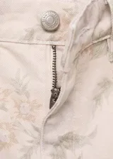 Pantalón jeans de corte wide leg y tiro alto, confeccionado en algodón con estampado floral en tonos suaves. Presenta diseño de cinco bolsillos, cierre frontal con cremallera y botón, y trabillas en la cintura.