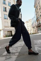Pantalón jogger de tiro medio, color bordó, con cintura elástica ajustable mediante cordones, bolsillos delanteros y puños elásticos en los tobillos.