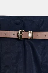 Pantalón tobillero de tiro medio, color azul marino, con bolsillos delanteros y cierre frontal con cremallera, botón y gancho. Incluye un cinturón fino de color marrón con hebilla metálica.