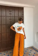 Pantalón de mujer color naranja, de corte palazzo y cintura alta con cordón ajustable.