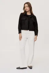 Pantalón de tiro medio y corte wide leg color beige, con diseño clásico de cinco bolsillos, presillas para cinto y cierre frontal con botón y cremallera.