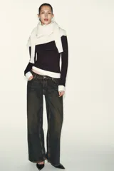 Camiseta de manga larga color gris melange, con cuello redondo y bajo recto. Presenta un detalle de tejido efecto doble a contraste en el cuello, puños y dobladillo inferior en color blanco.