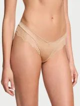 Bombacha tipo bikini de tiro bajo y pierna alta, color praline, confeccionada con detalles de encaje floral en los laterales.